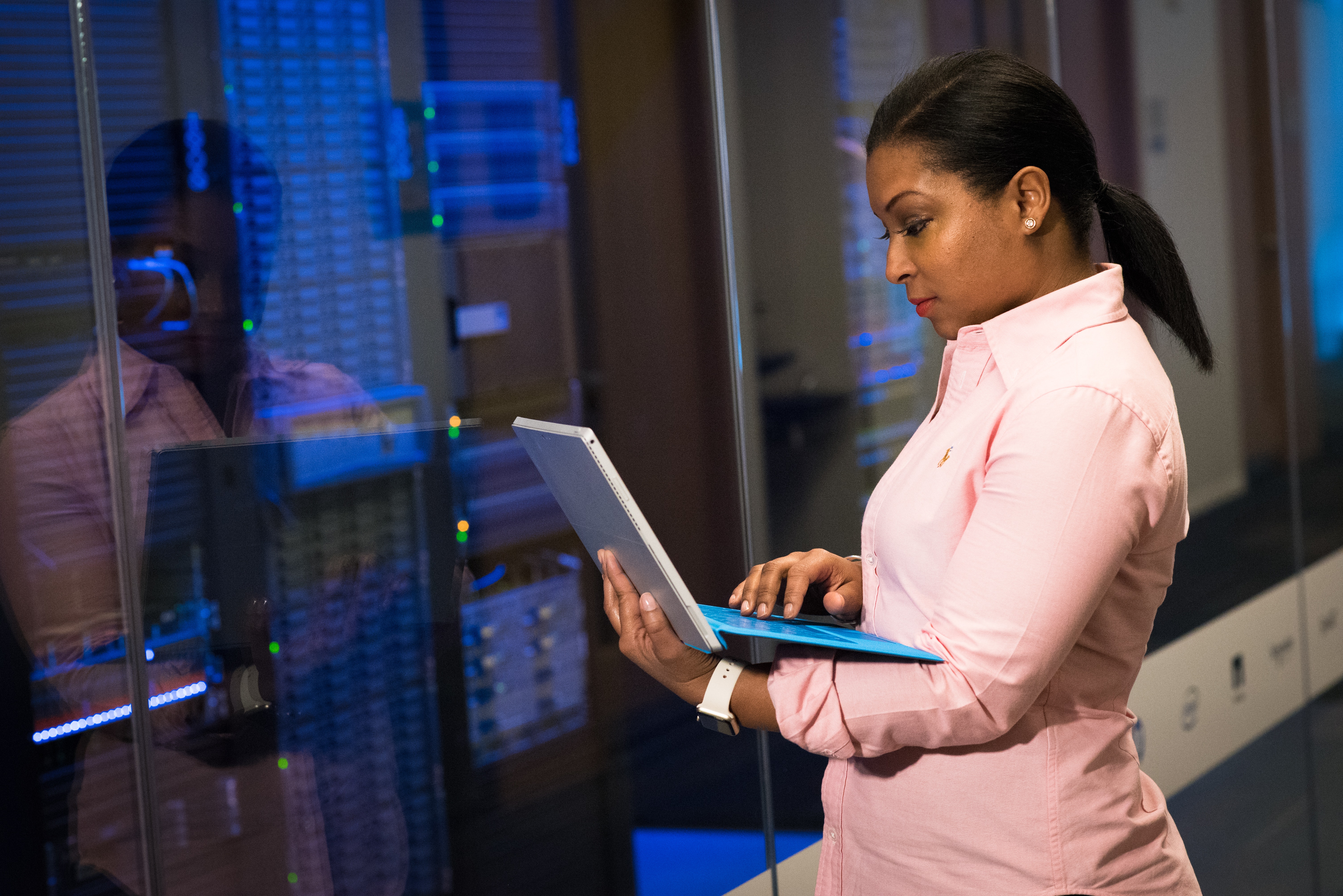 Female digital support looking at laptop in server room