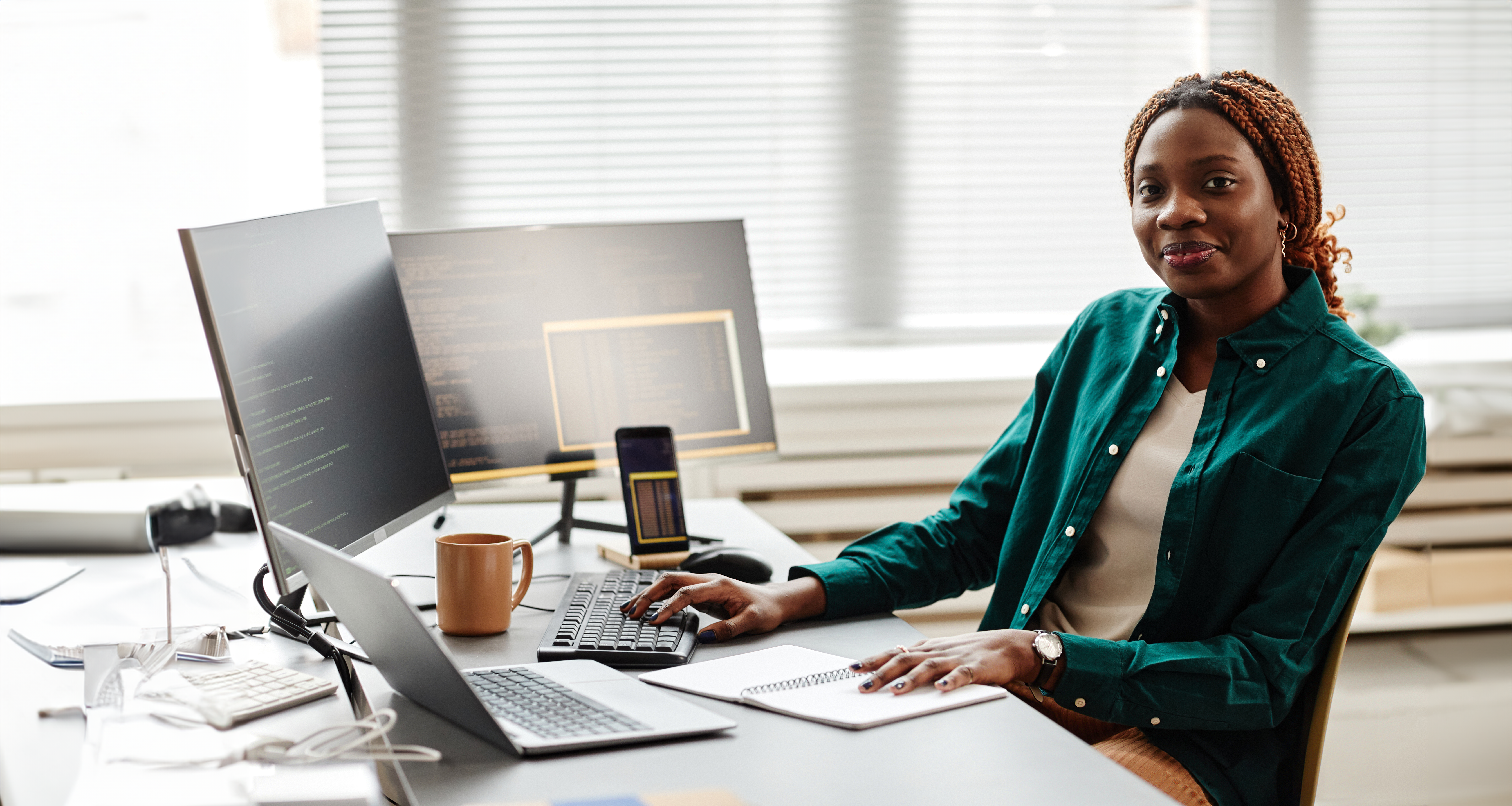 Software developer wearing a green shirt sat at desk