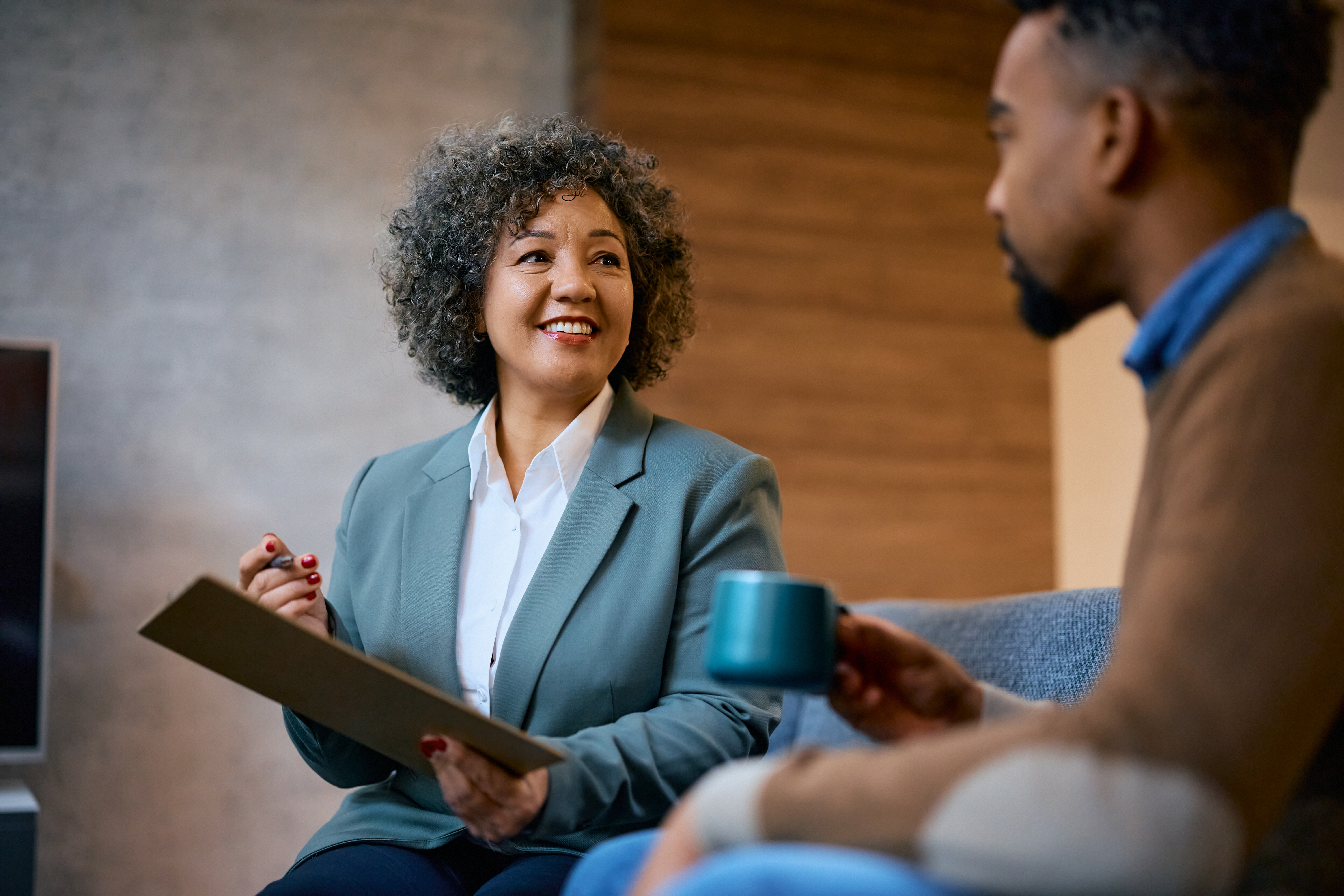 Happy female financial agent advising African American client during a meeting in the office.