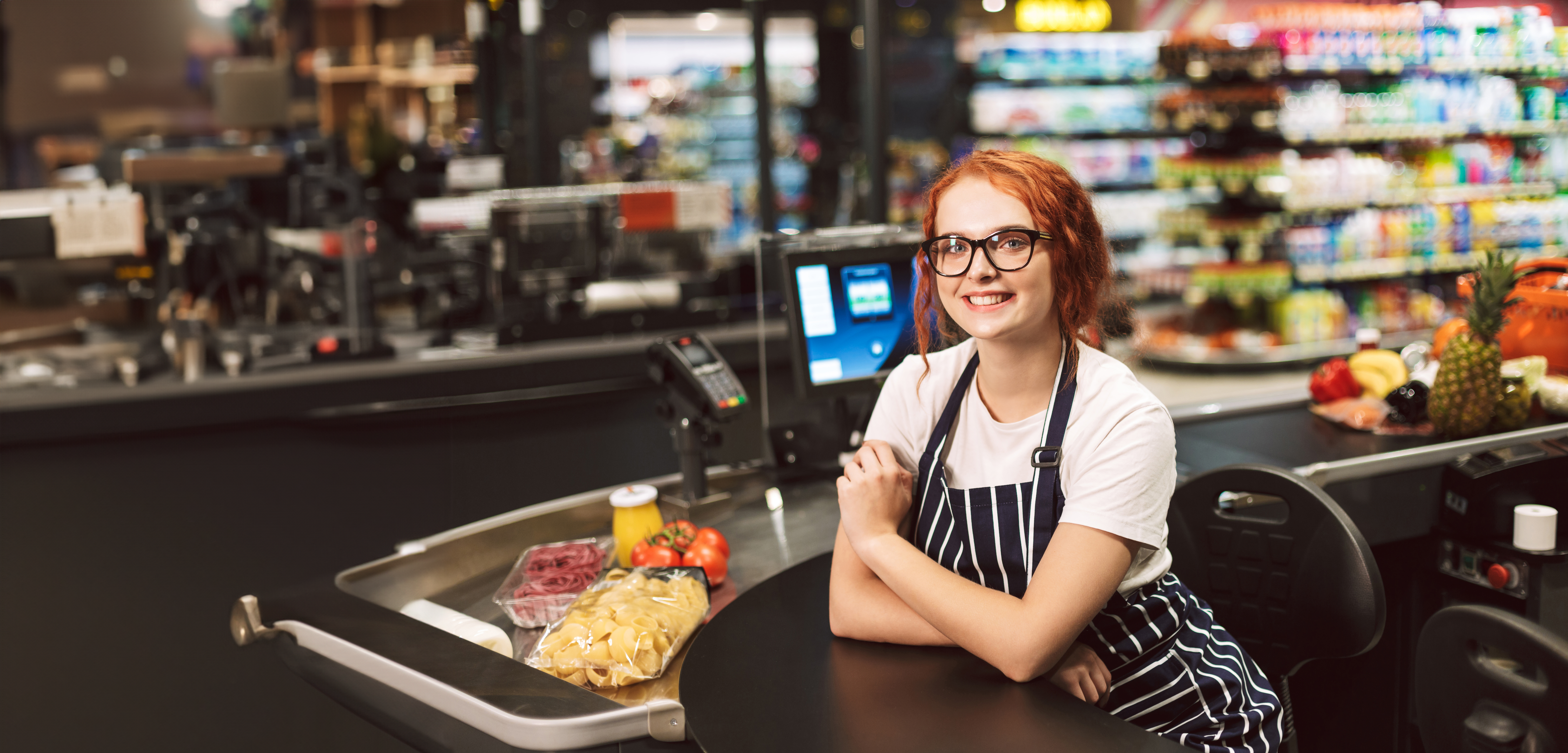 Female retail assistant at shop tills