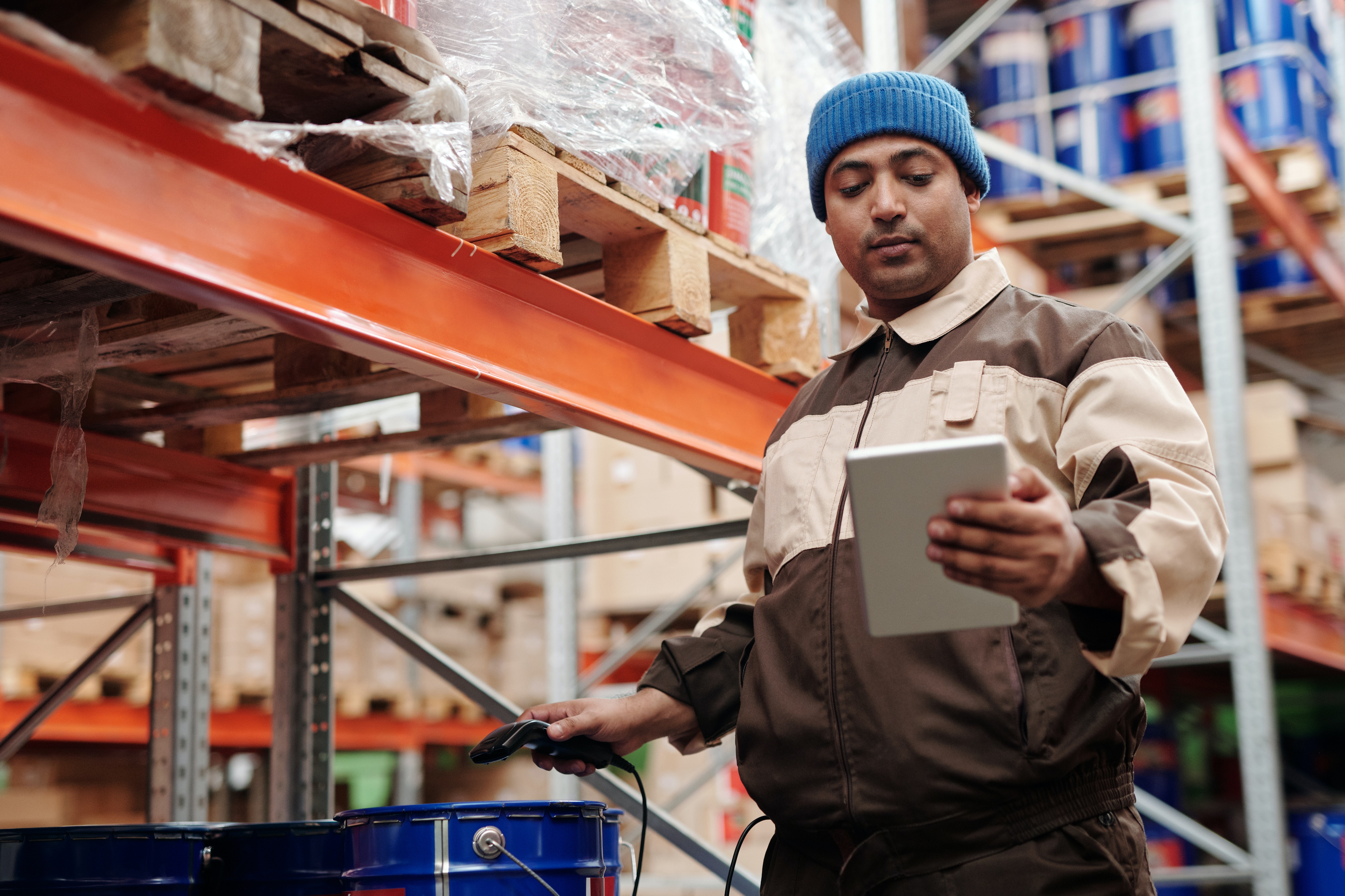 Warehouse assistant looking at tablet in warehouse