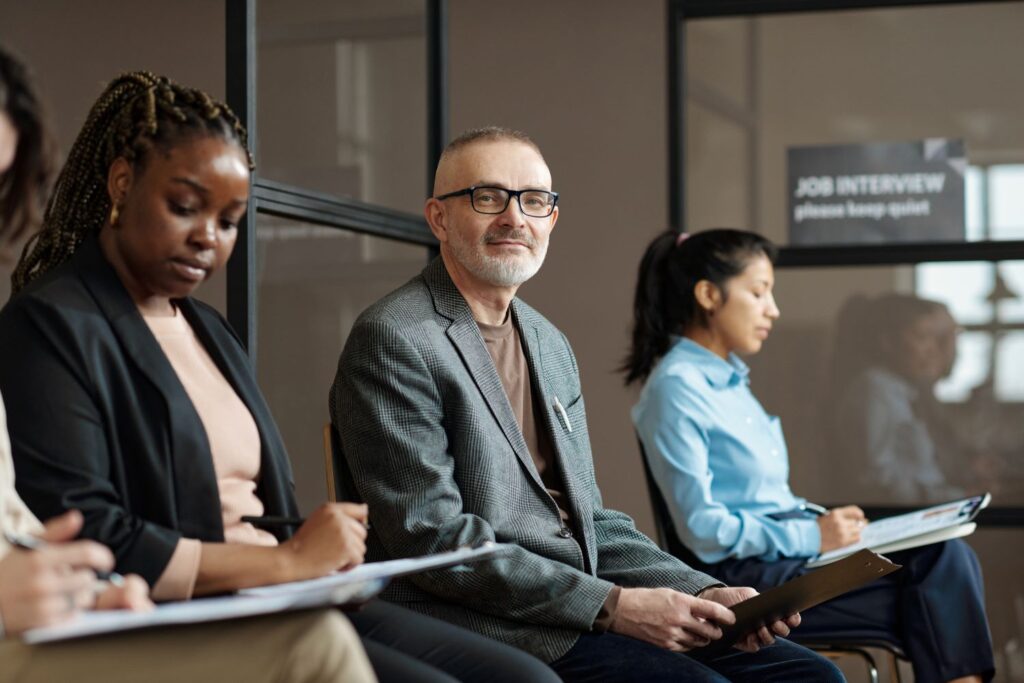 Man sat in a group interview and questioning session. 