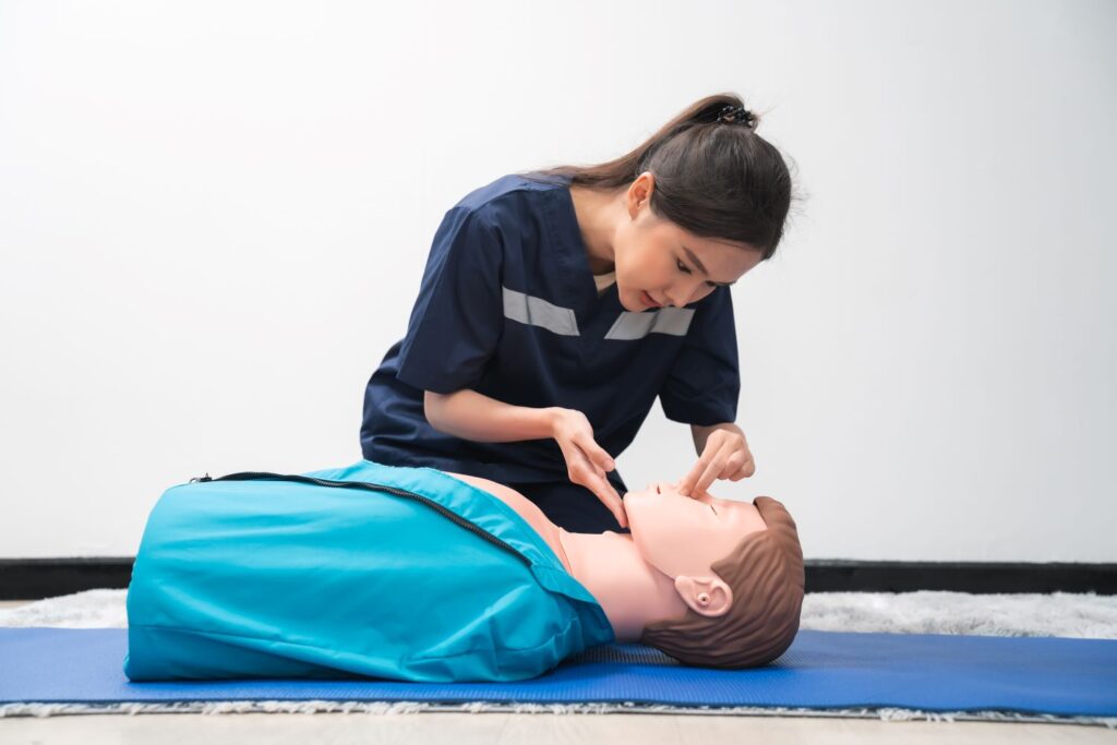 Emergency first aid being administered to a CPR doll 